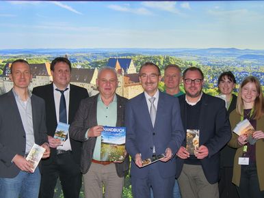 Der Vorstand und Partner der Tourismusregion vor der neuen Messewand